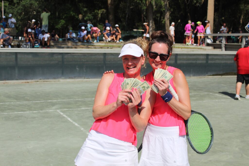 Womens doubles winning money at tennis party. 